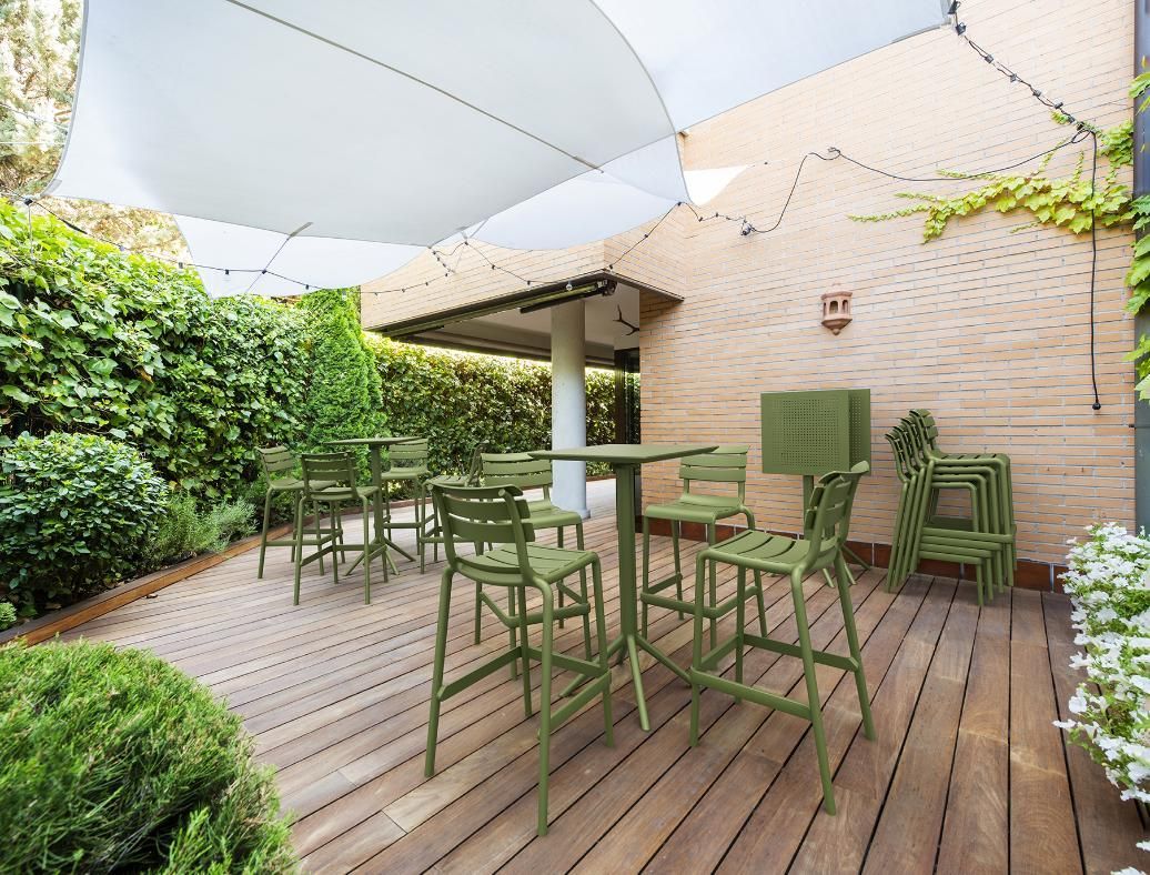 A Wooden Deck with Green Chairs and Tables Under an Umbrella — Creative Commercial Furniture in Cairns City, QLD