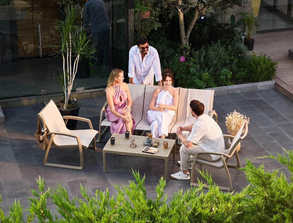 A Group of People Are Sitting on A Patio Talking to Each Other — Creative Commercial Furniture in Byron Bay, QLD