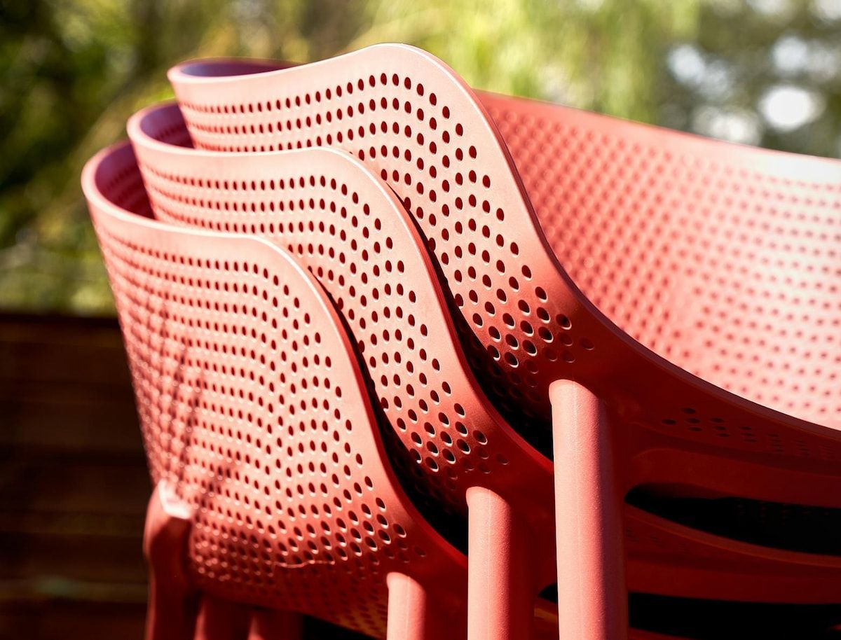 Stack of Coral-colored Plastic Chairs — Creative Commercial Furniture in Airlie Beach, QLD