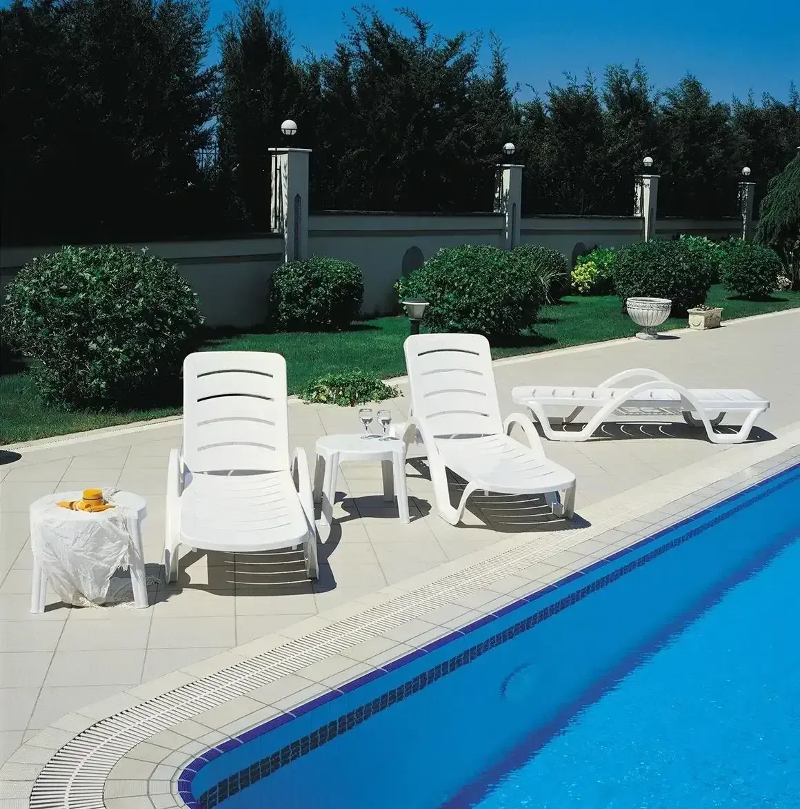 White Lounge Chairs Near a Blue Swimming Pool, on a Sunny Patio — Creative Commercial Furniture in Townsville, QLD
