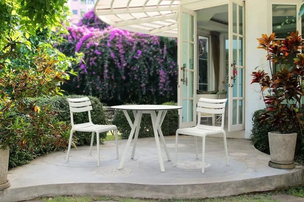 A Table and Chairs Are Sitting on a Patio in Front of a House — Creative Commercial Furniture in Cairns City, QLD 