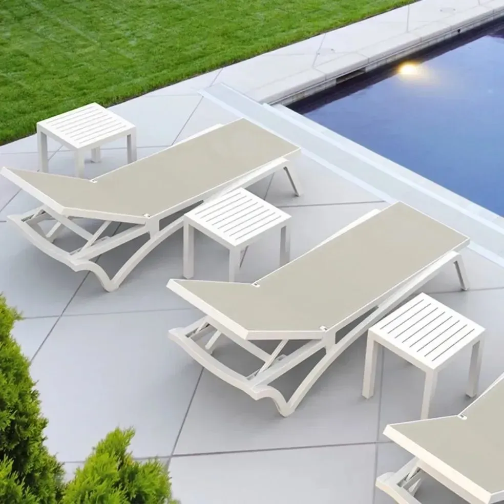 Beige Lounge Chairs With Small White Tables Beside a Pool — Creative Commercial Furniture in Newcastle, NSW