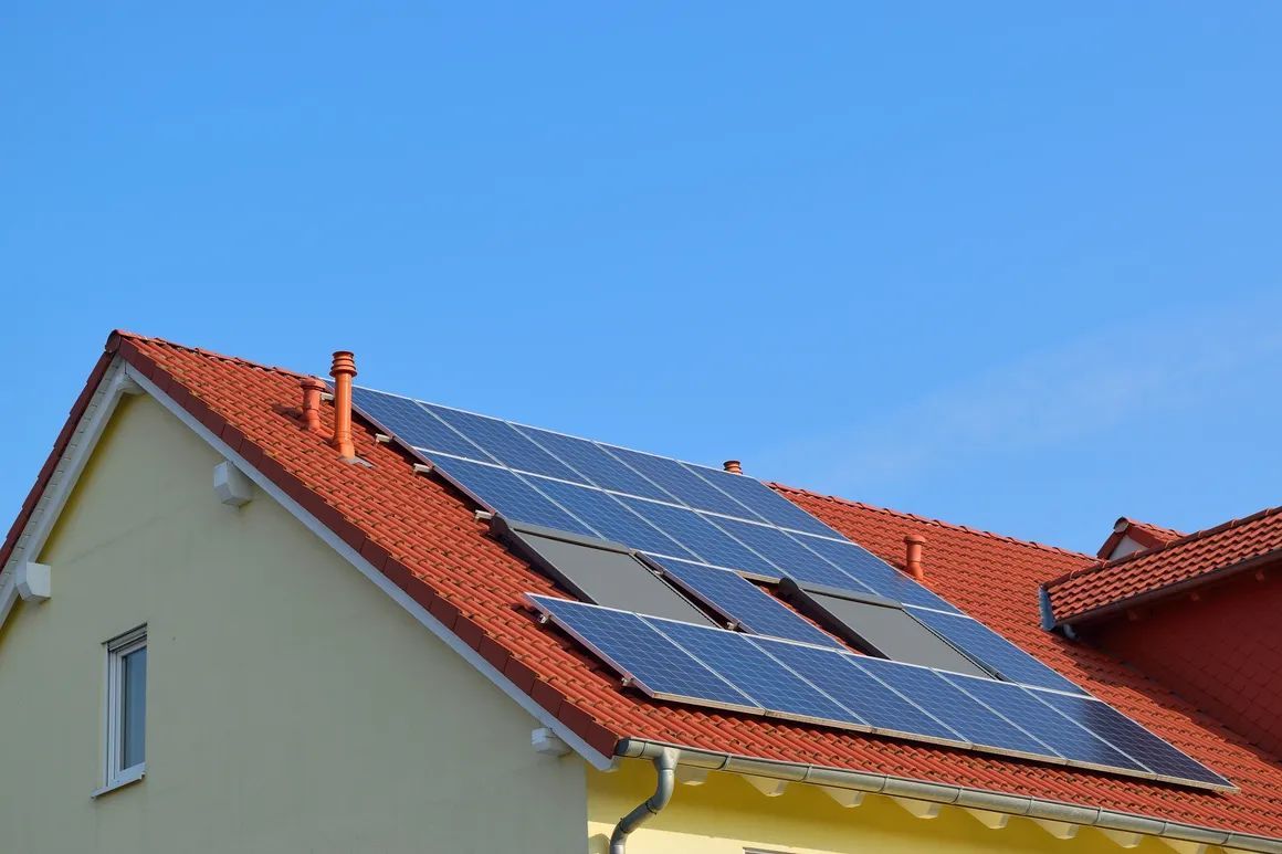House roof with solar panels under a clear blue sky