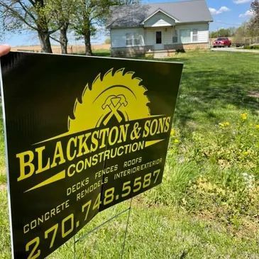 Blackston & Sons Construction sign staked in a grassy yard with a house in the background