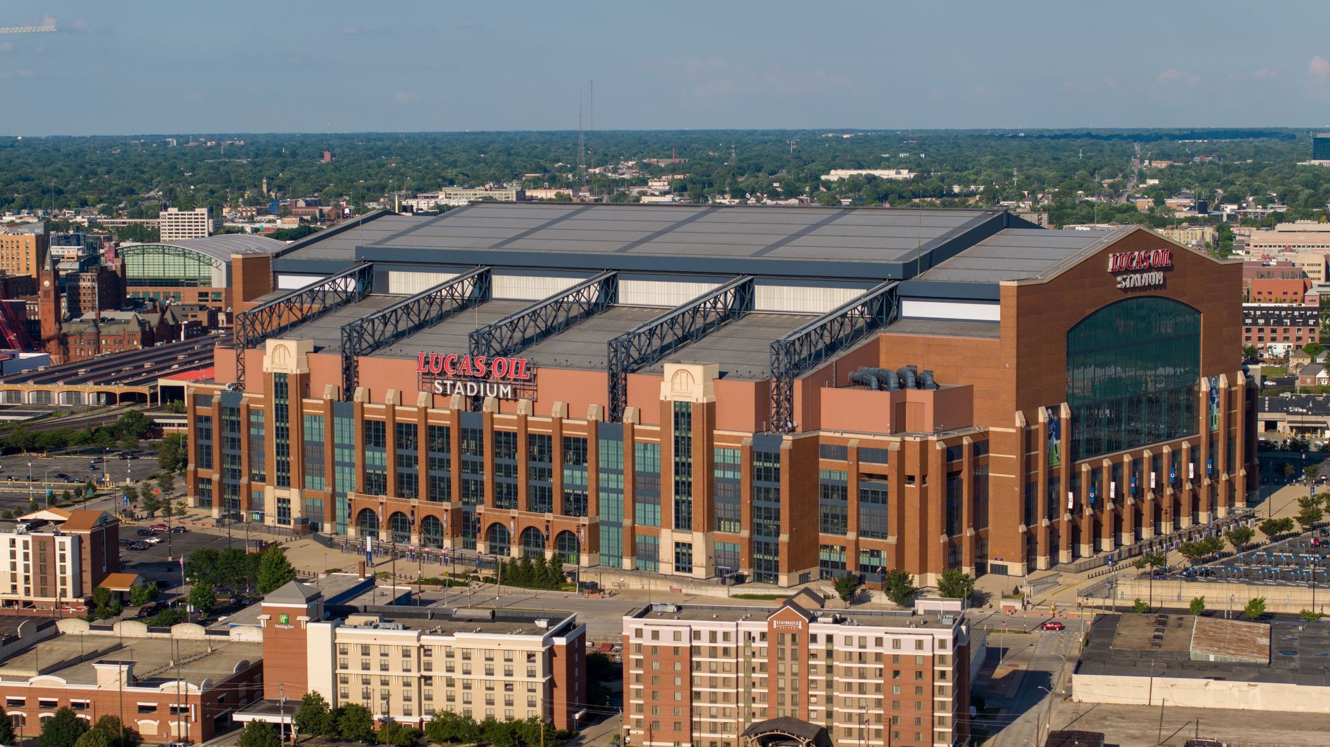 Aerial view of a large brick-and-glass sports stadium in a city