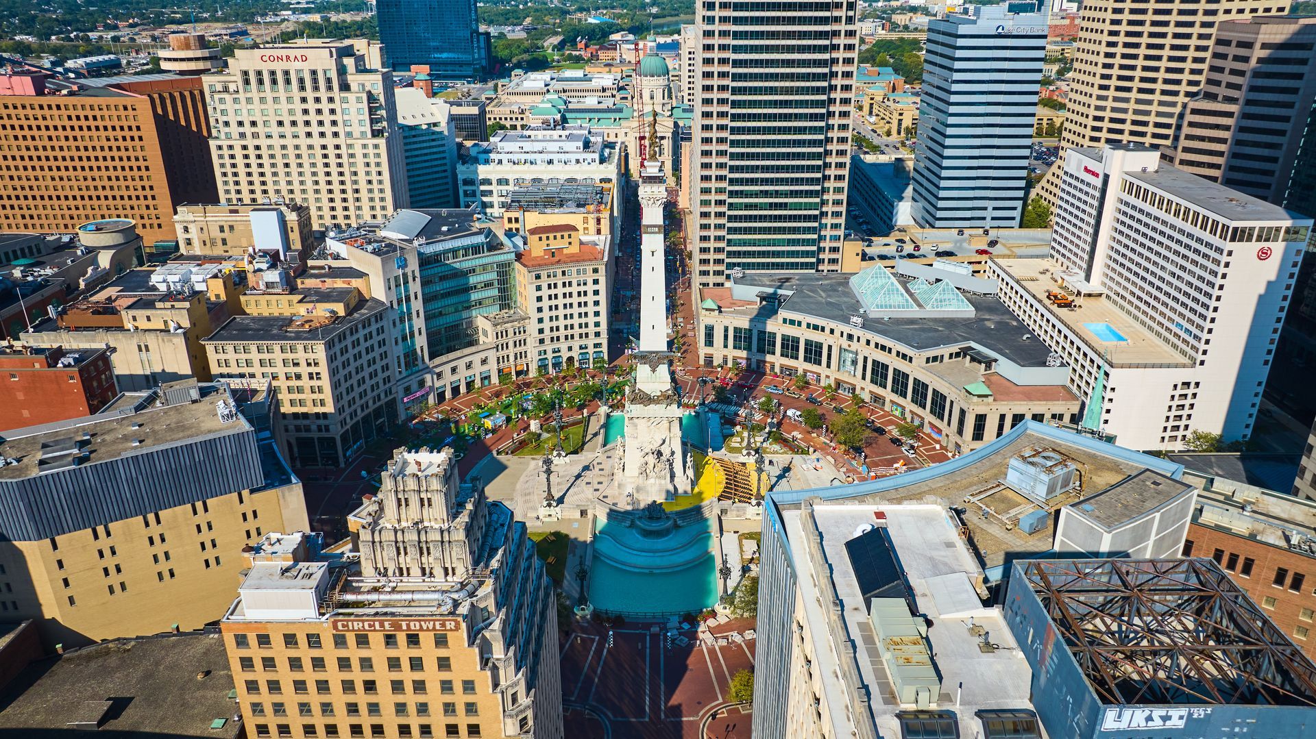Aerial view of a dense downtown with high-rise buildings and streets in bright daylight.