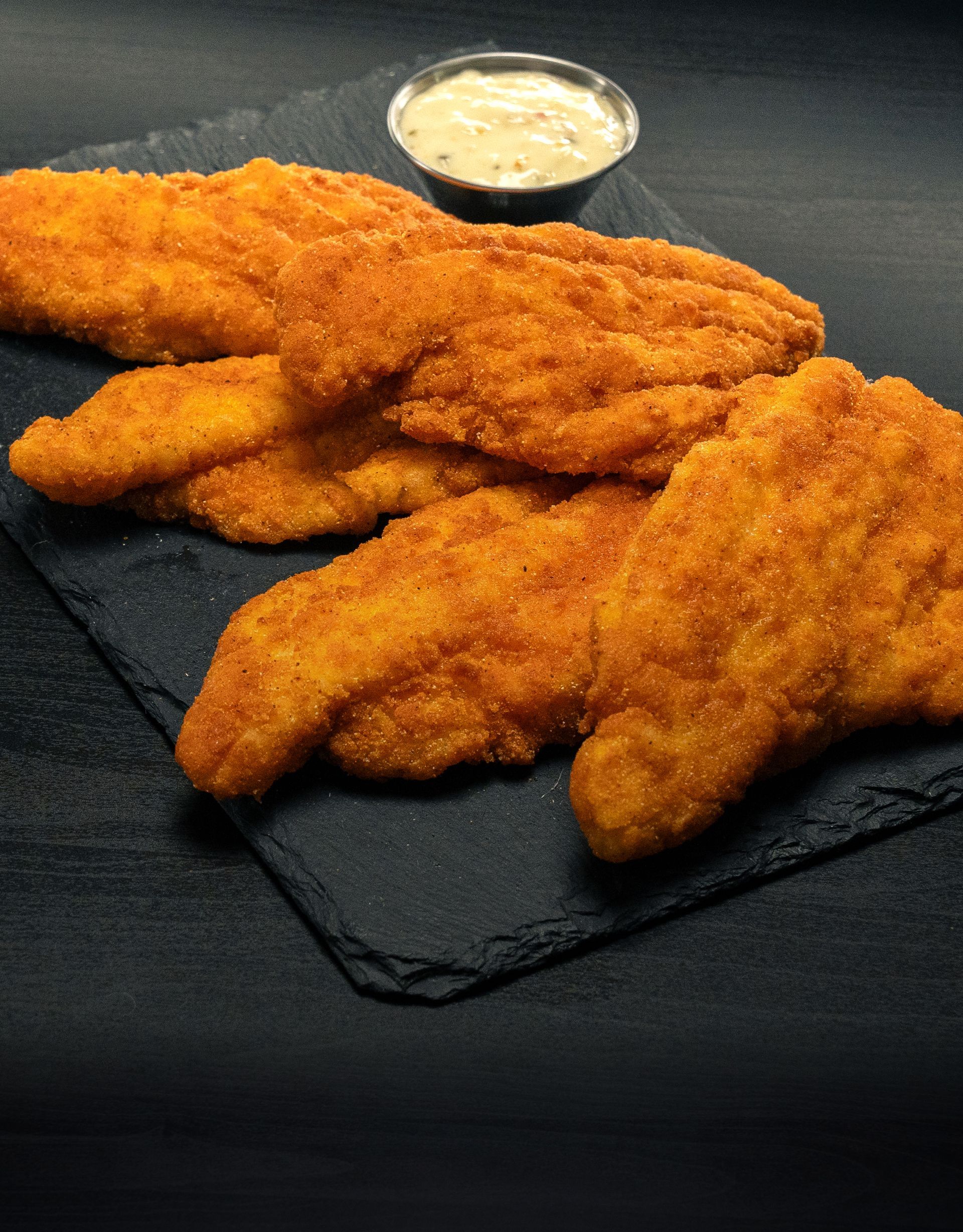 A plate of fried Catfish with a side of tartar sauce