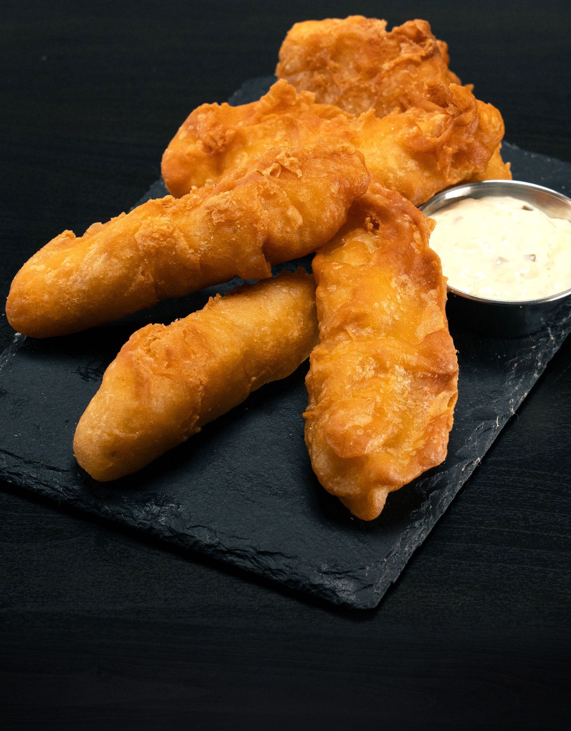 A plate of fried food with a dipping sauce on it