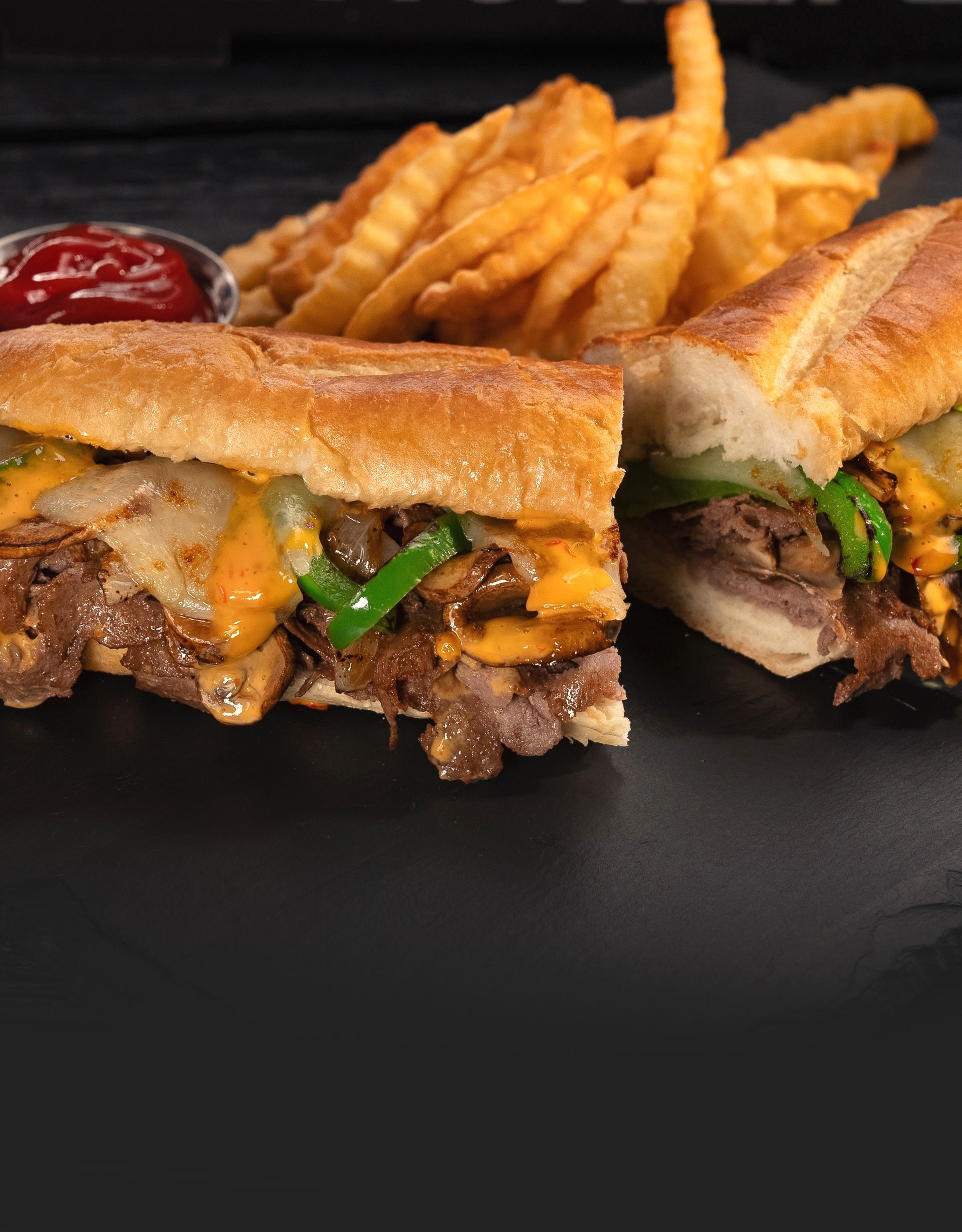 Philly Cheesesteak Sub: Thinly sliced steak, melted cheese, and grilled onions packed into a warm, toasted bun.