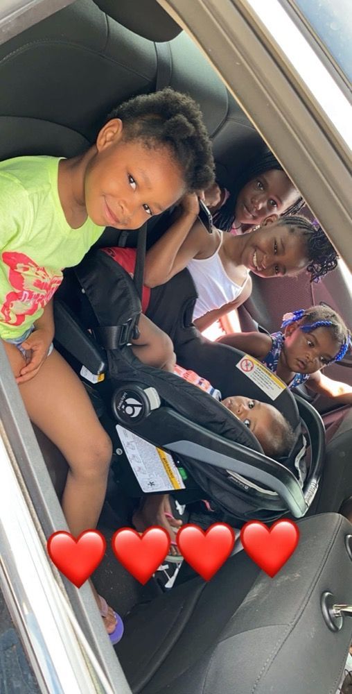 A group of children are sitting in the back seat of a car.
