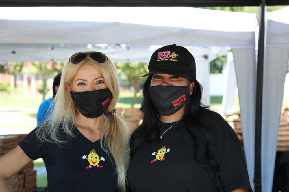 Two women wearing face masks are posing for a picture.
