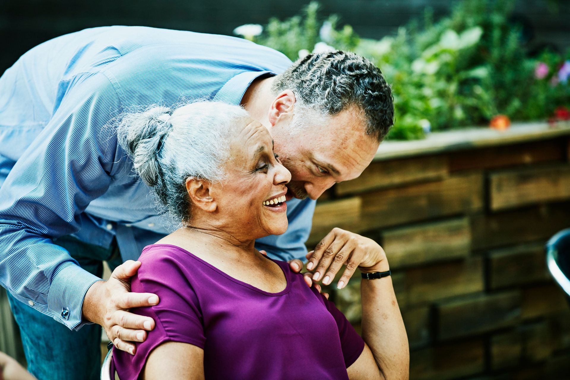A man is kissing an older woman on the cheek.