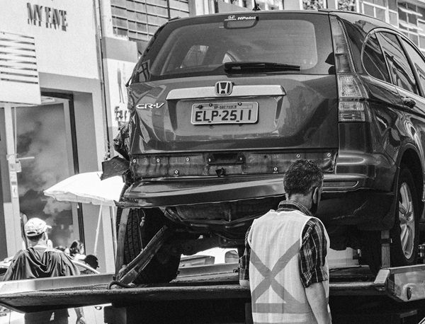 A damaged SUV on a flatbed tow truck.