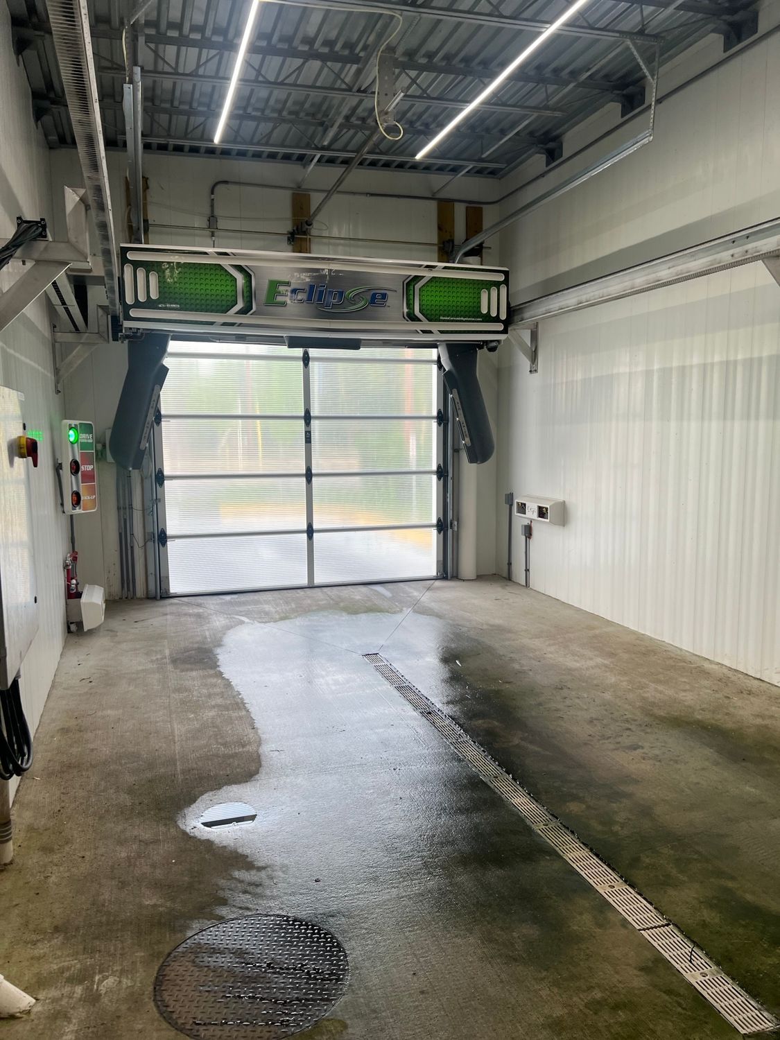 The inside of a car wash with a large garage door. | Duffy's Auto Service