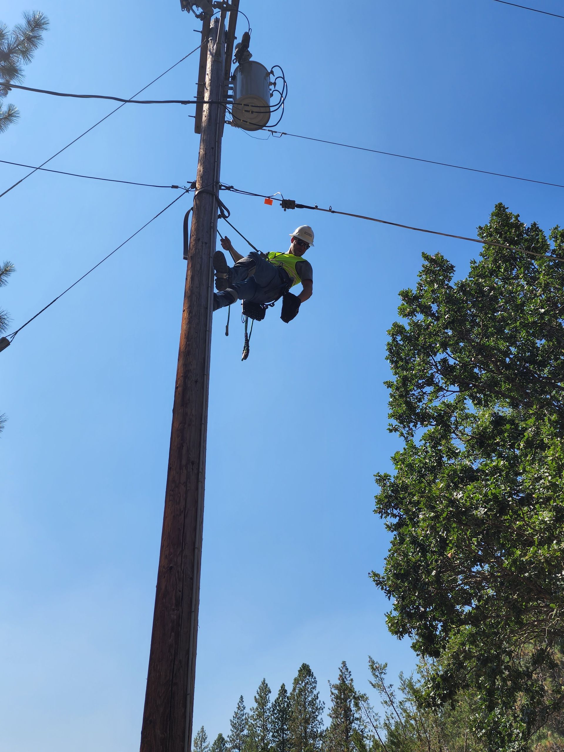 Grover Construction LLC workers inspecting utility poles for compliance and safety