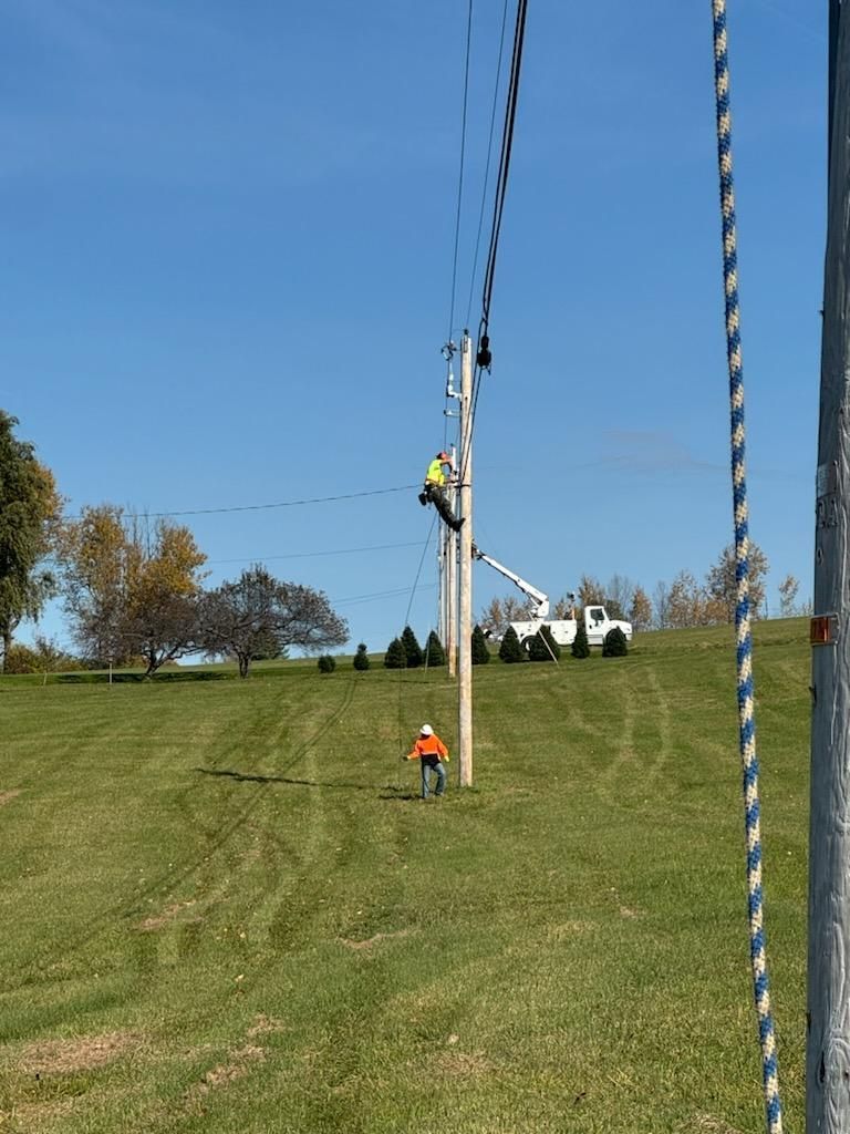 Telecommunications workers on a pole servicing utility lines.