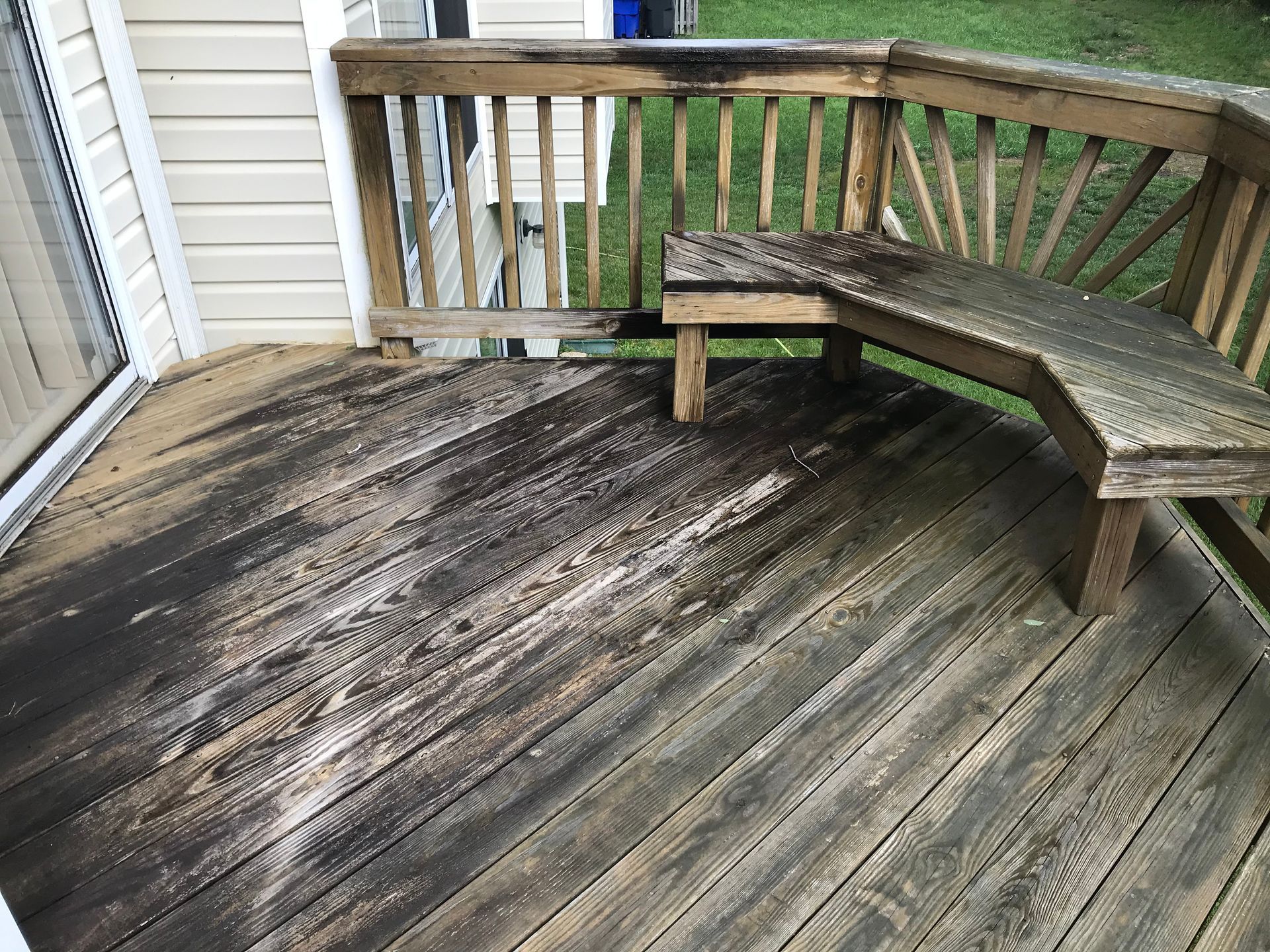 A wooden deck with a bench and railing.