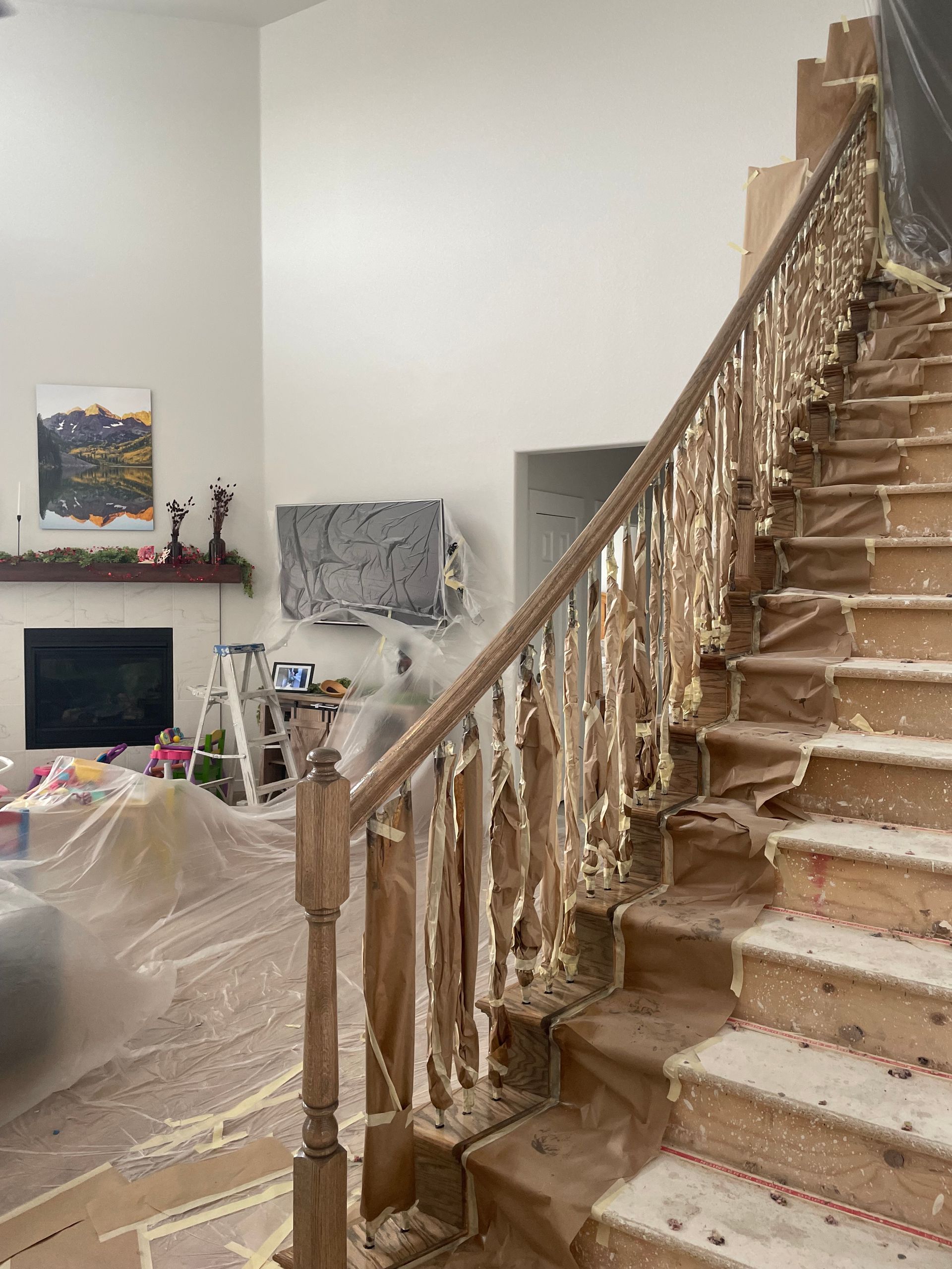 A Staircase With A Wooden Railing Is Being Painted In A Living Room