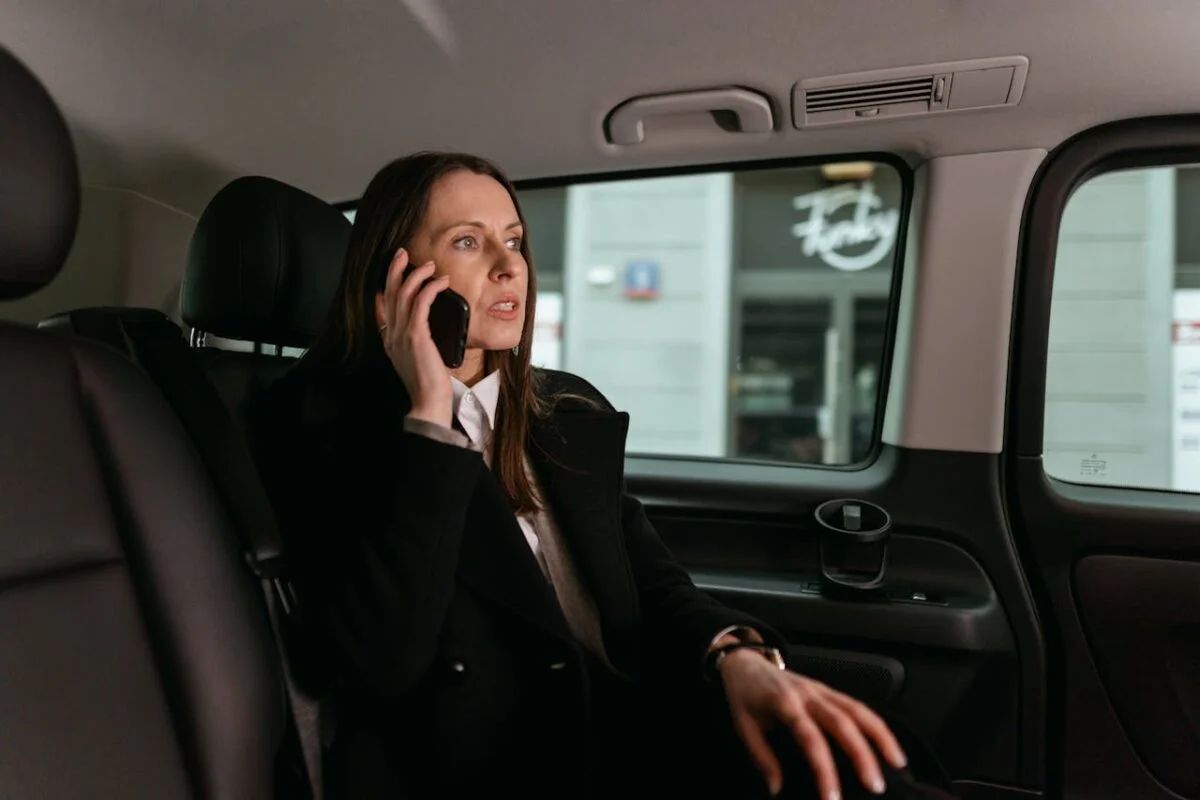 A woman is sitting in the back seat of a car.