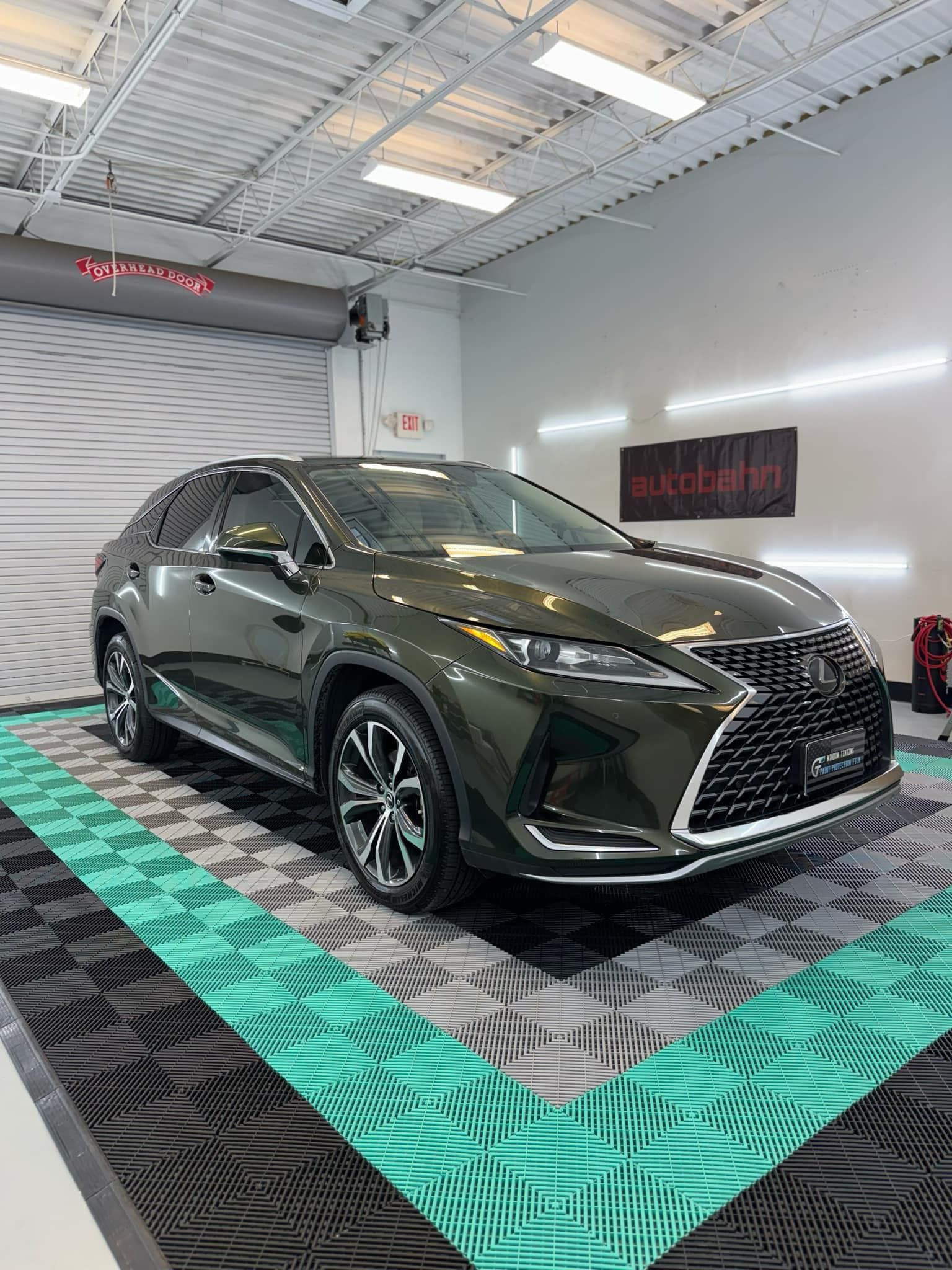 Dark green Lexus RX SUV with premium window tint installed, inside GT Tinting's professional shop in Hampton, VA, featuring Autobahn performance film.