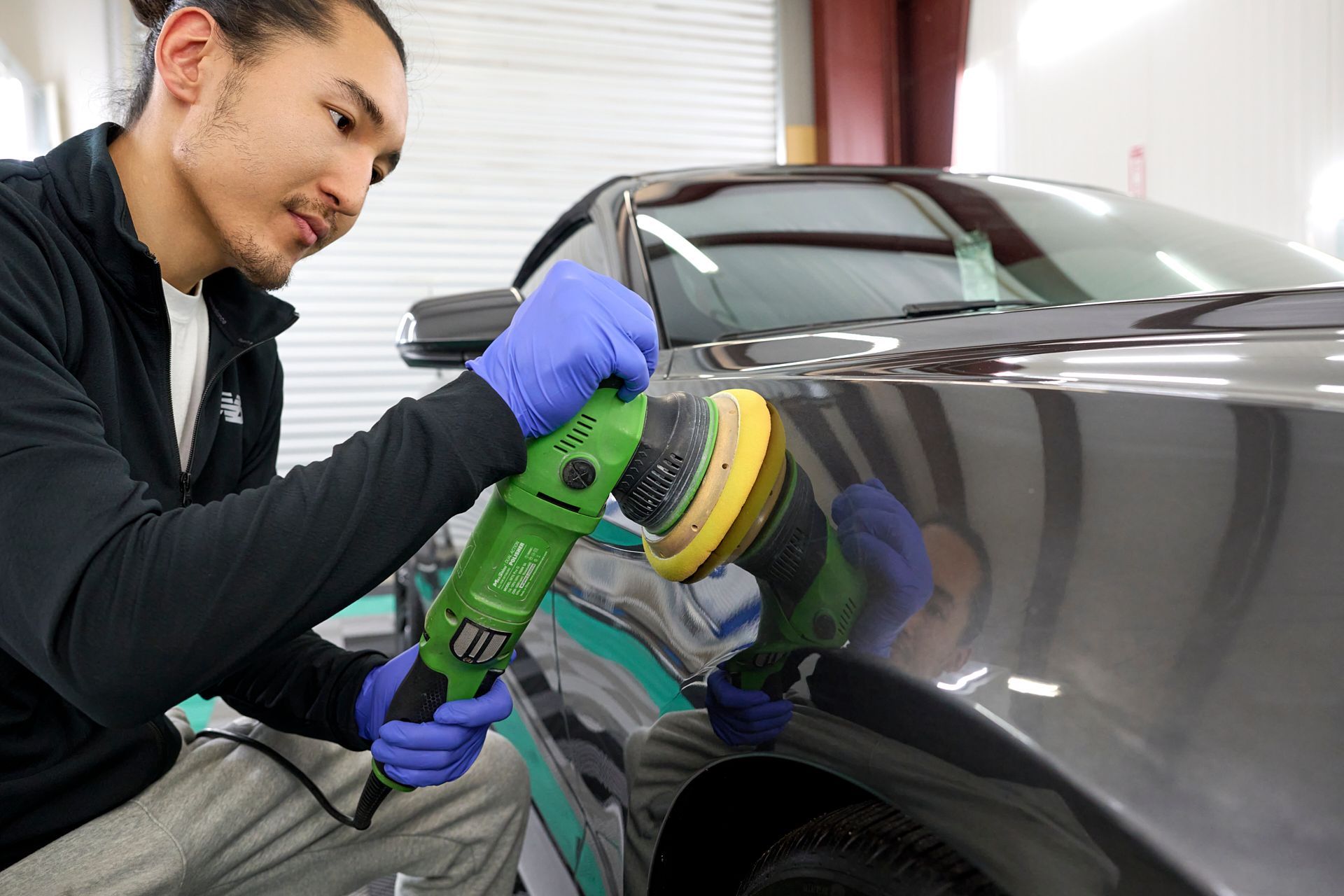 Technician polishing vehicle paint before ceramic coating application, GT Tinting Hampton VA