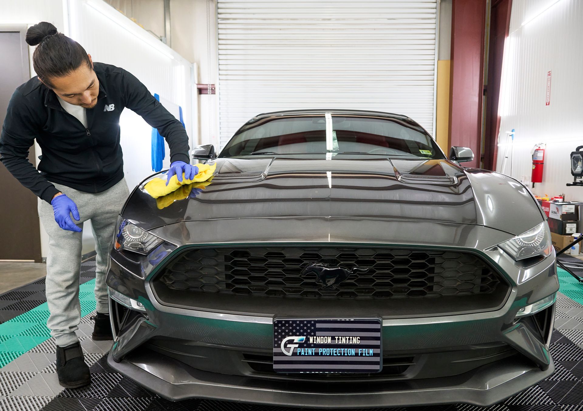 Technician applying ceramic coating to a Ford Mustang at GT Tinting in Hampton, VA