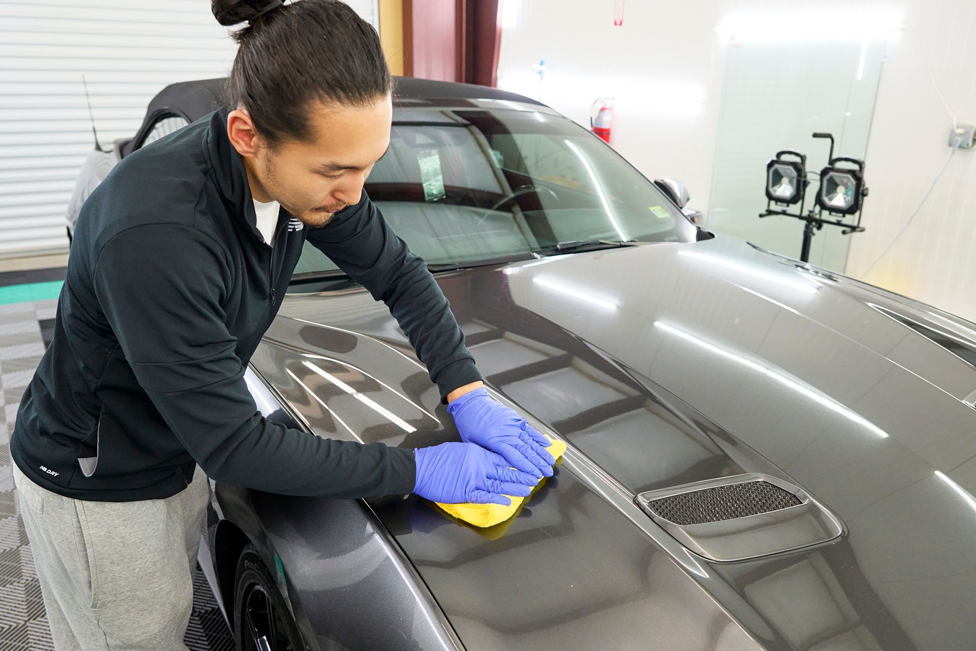 Technician applying ceramic coating to Mustang exterior, GT Tinting Hampton VA