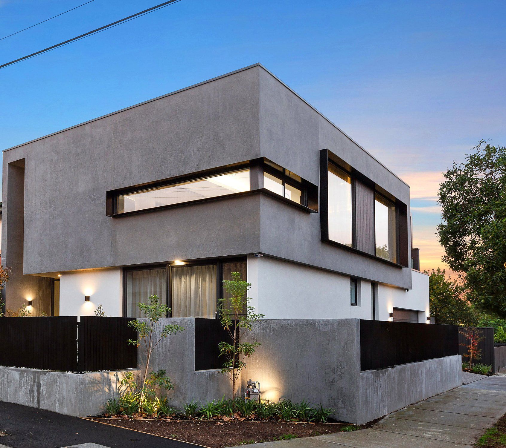 A modern house with a black fence in front of it