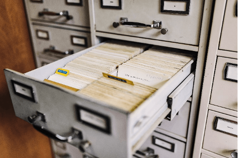 A filing cabinet with a drawer open filled with cards.