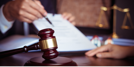 A judge is holding a pen over a piece of paper.