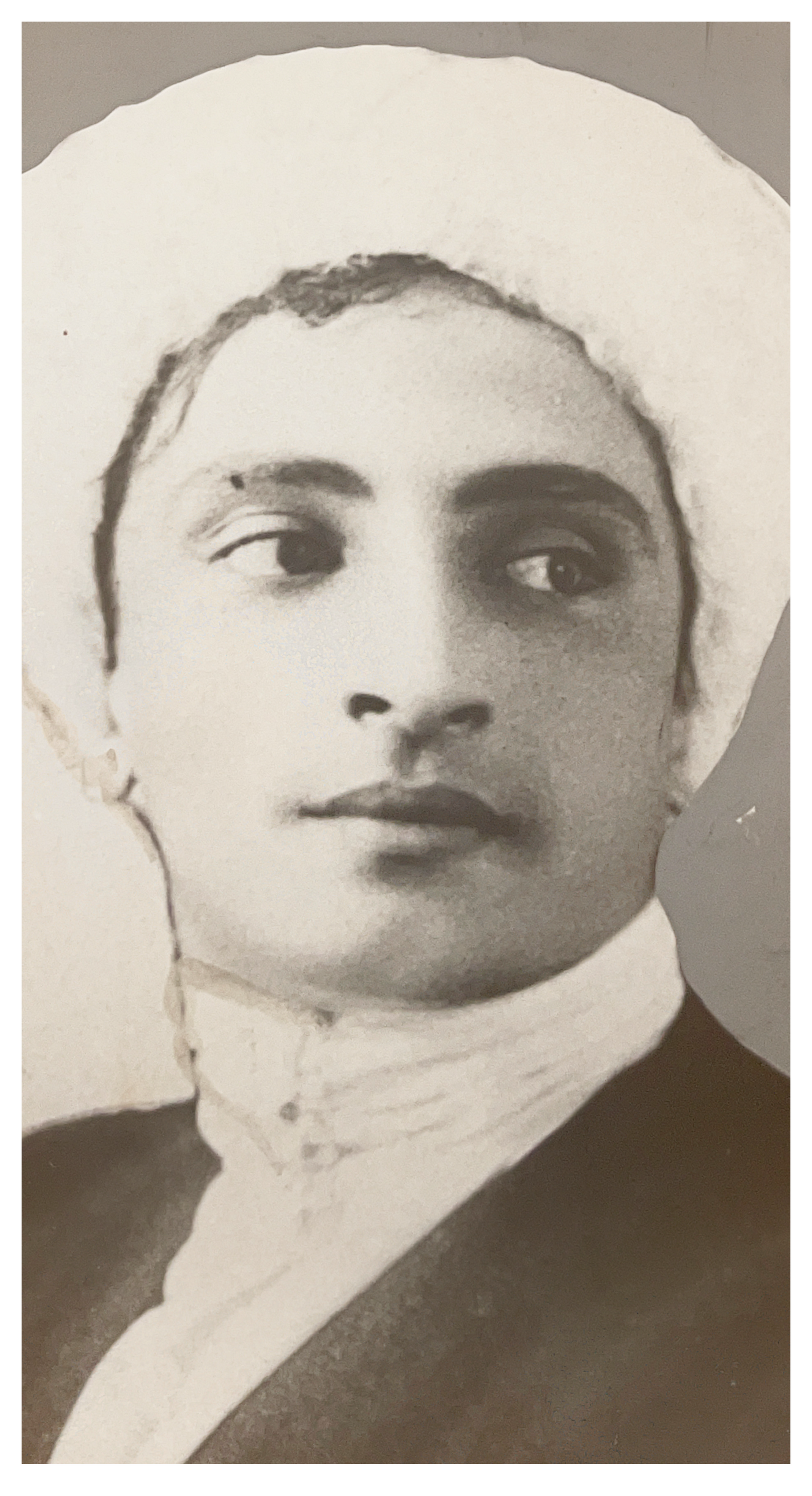Black-and-white studio portrait of Alexis Merab in traditional headwear, facing forward with a neutral expression.