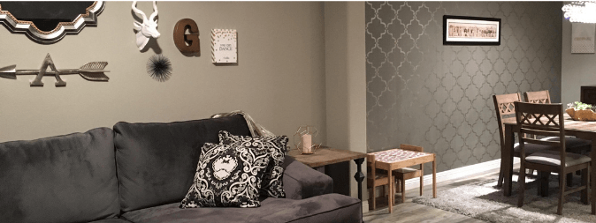Inside a Las Vegas Home shows couch, dining table and accent wall in modern gray and wood colors