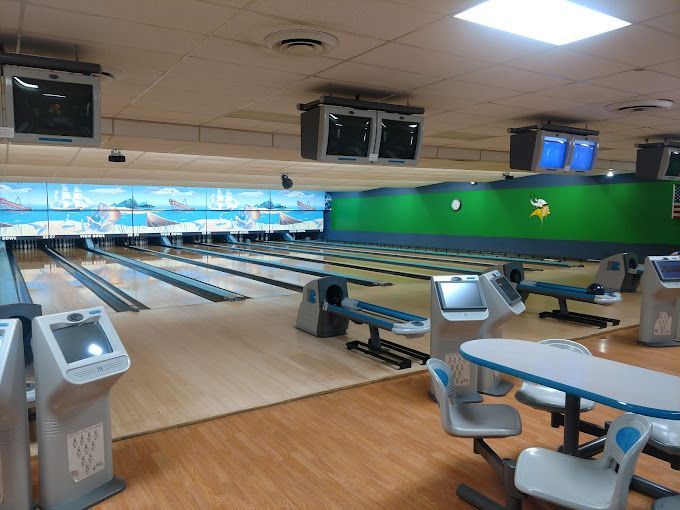 A bowling alley with a green wall and a table
