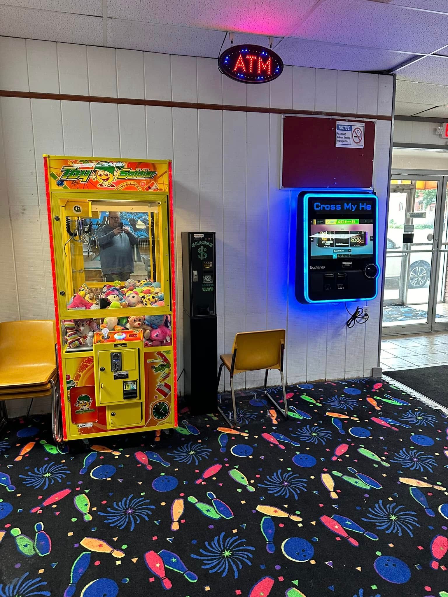 A room with a claw machine and an atm machine
