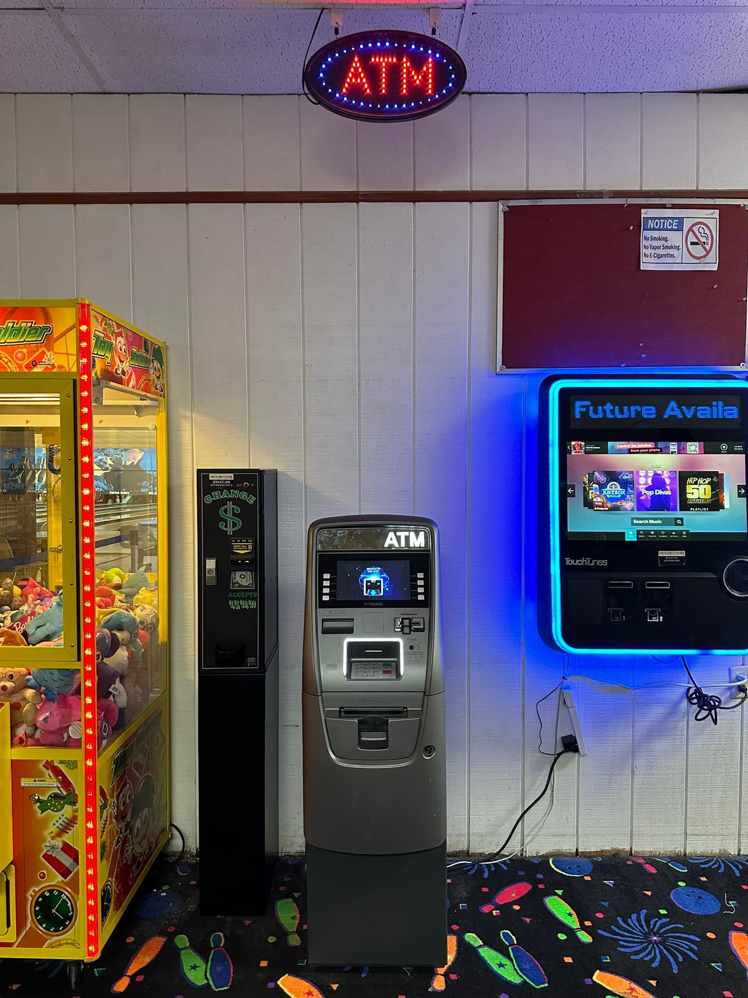 A room with a claw machine and an atm machine