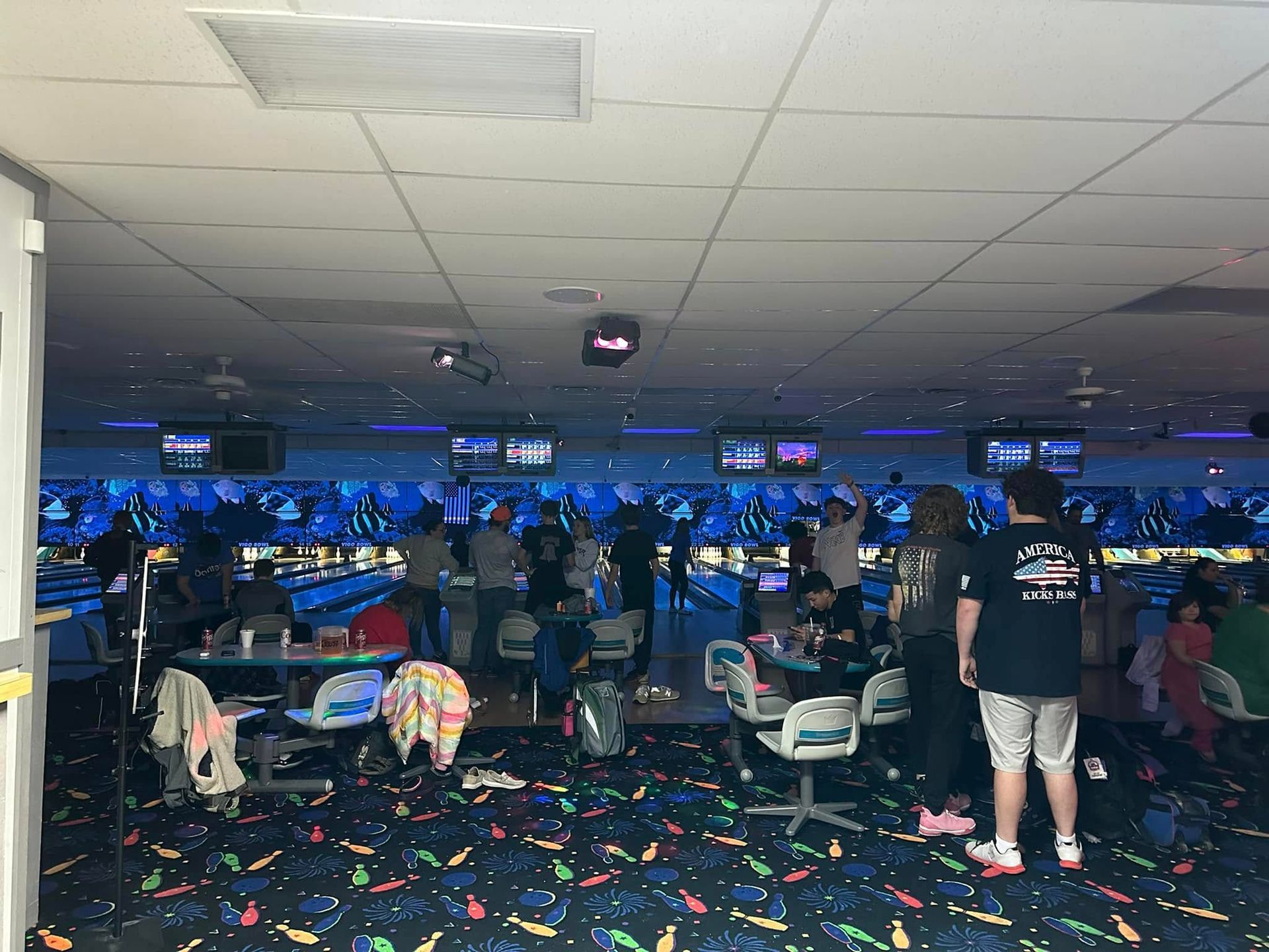 A group of people are playing bowling in a bowling alley