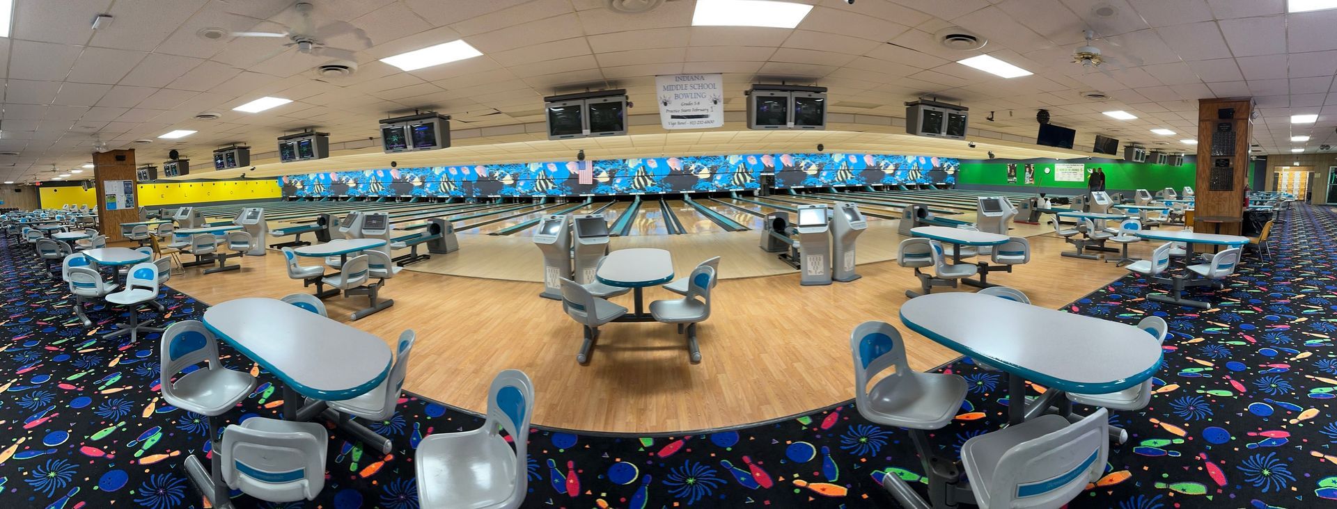 There are many tables and chairs in the bowling alley.