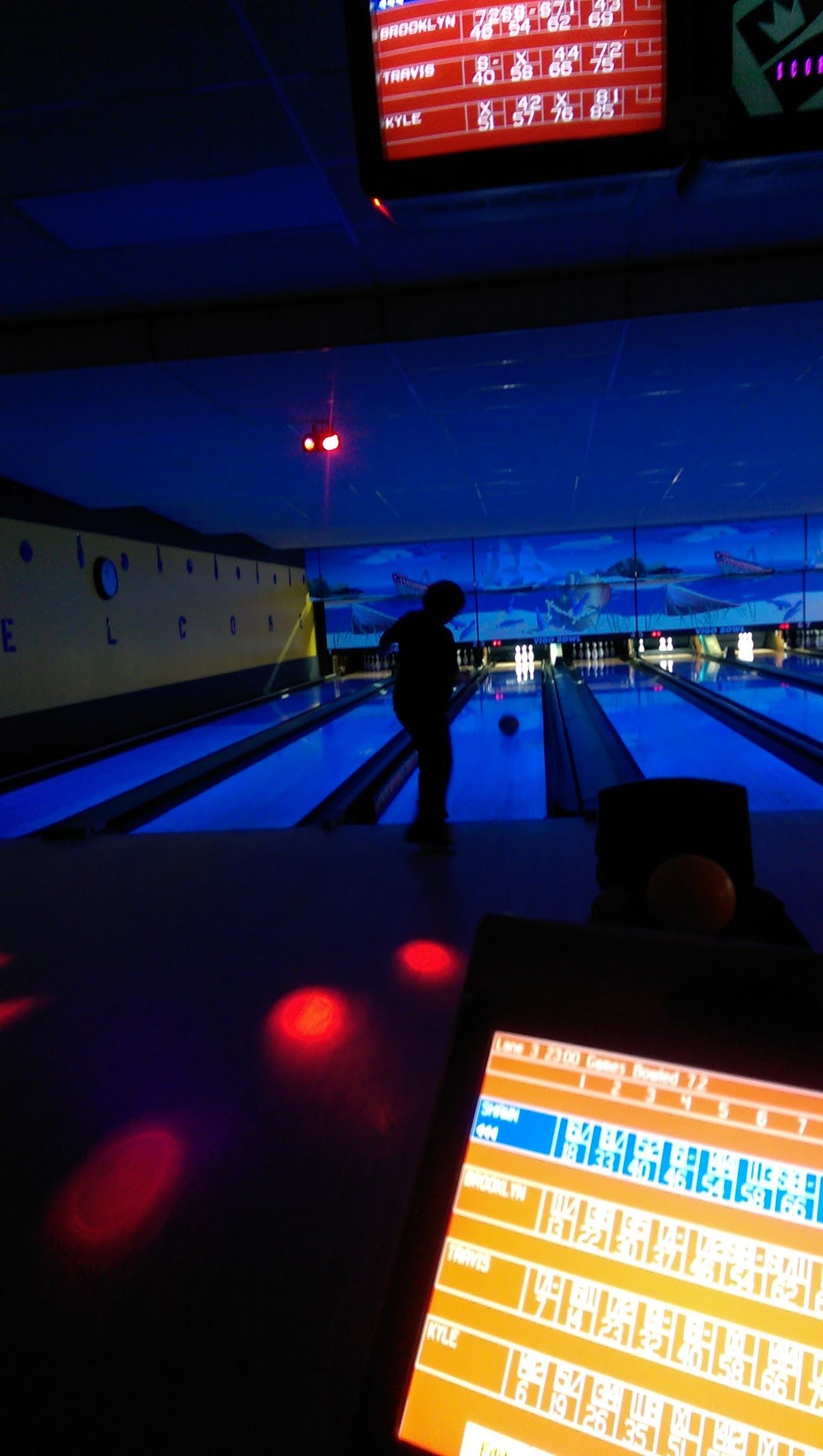 A bowling alley with a silhouette of a person in the background