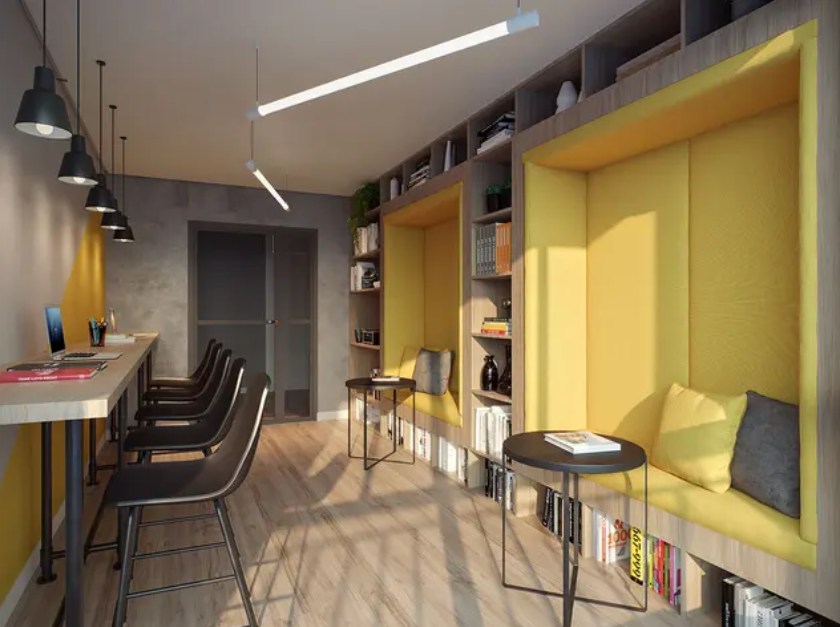 Interior de café moderno com cadeiras pretas, luminárias pendentes e assentos embutidos amarelos junto a grandes janelas.