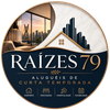 Logo circular da Ra&iacute;zes 79 para aluguel de curta temporada, com skyline, interior aconchegante e &iacute;cones de hospedagem.