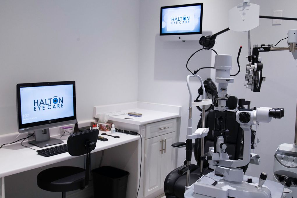 Eye clinic with vision-testing equipment, two monitors, and an examination chair.