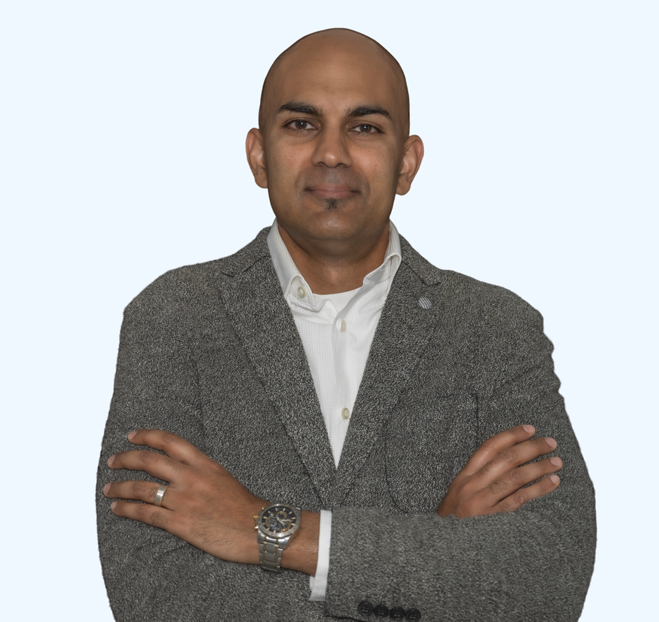 Portrait of a bald man in a gray blazer with arms crossed against a light background