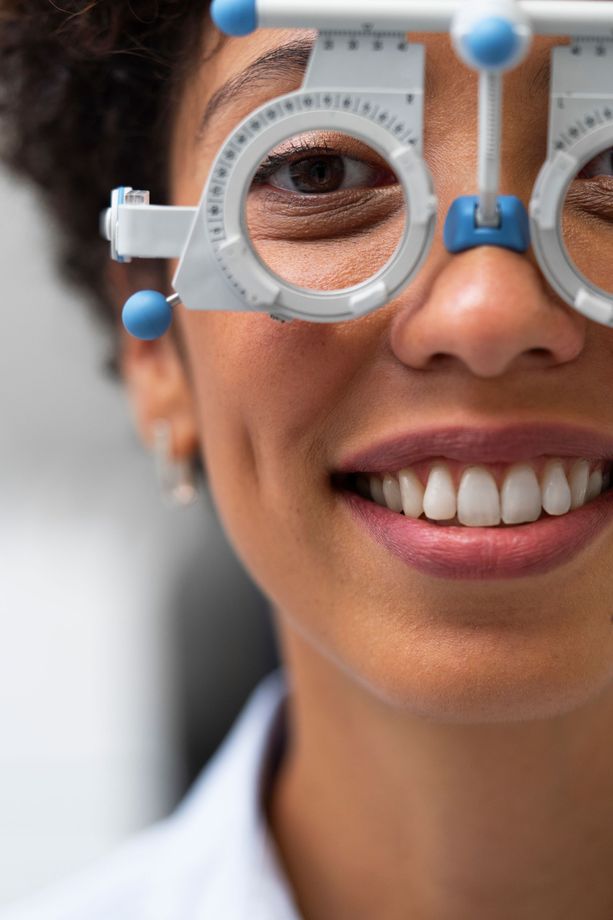 Person smiling through white round eyeglasses in a close-up portrait