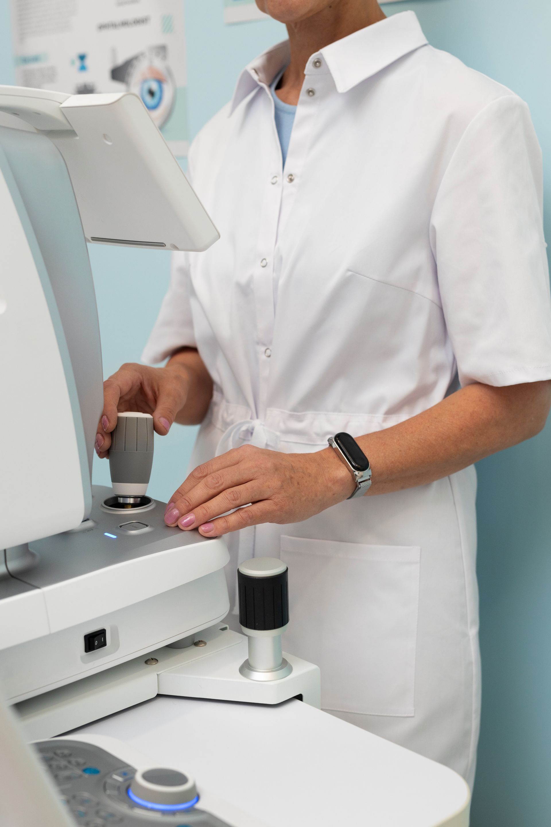 A woman in a white coat is working on a machine.