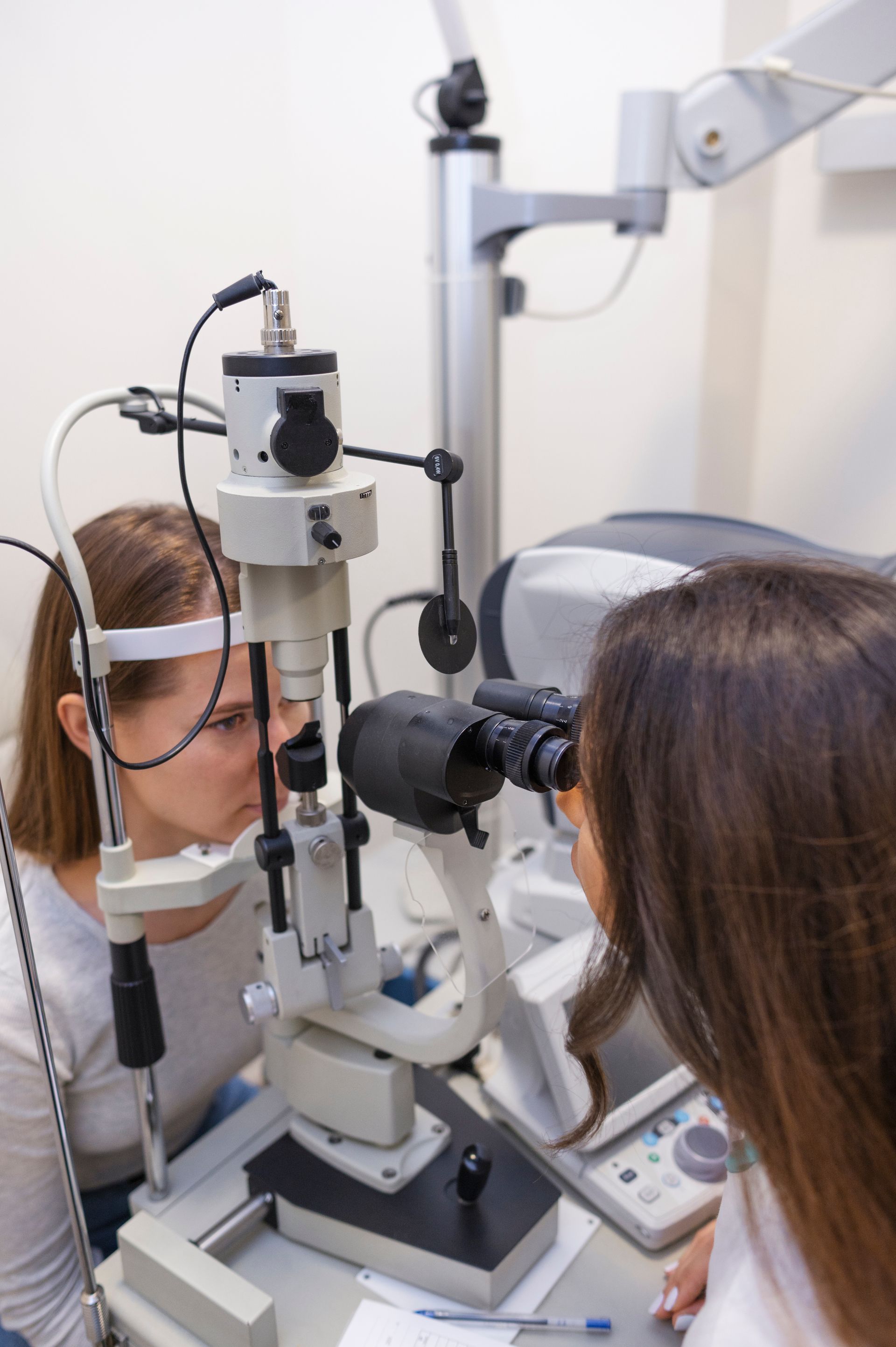 Eye exam with patient and optometrist using a slit lamp in a clinic