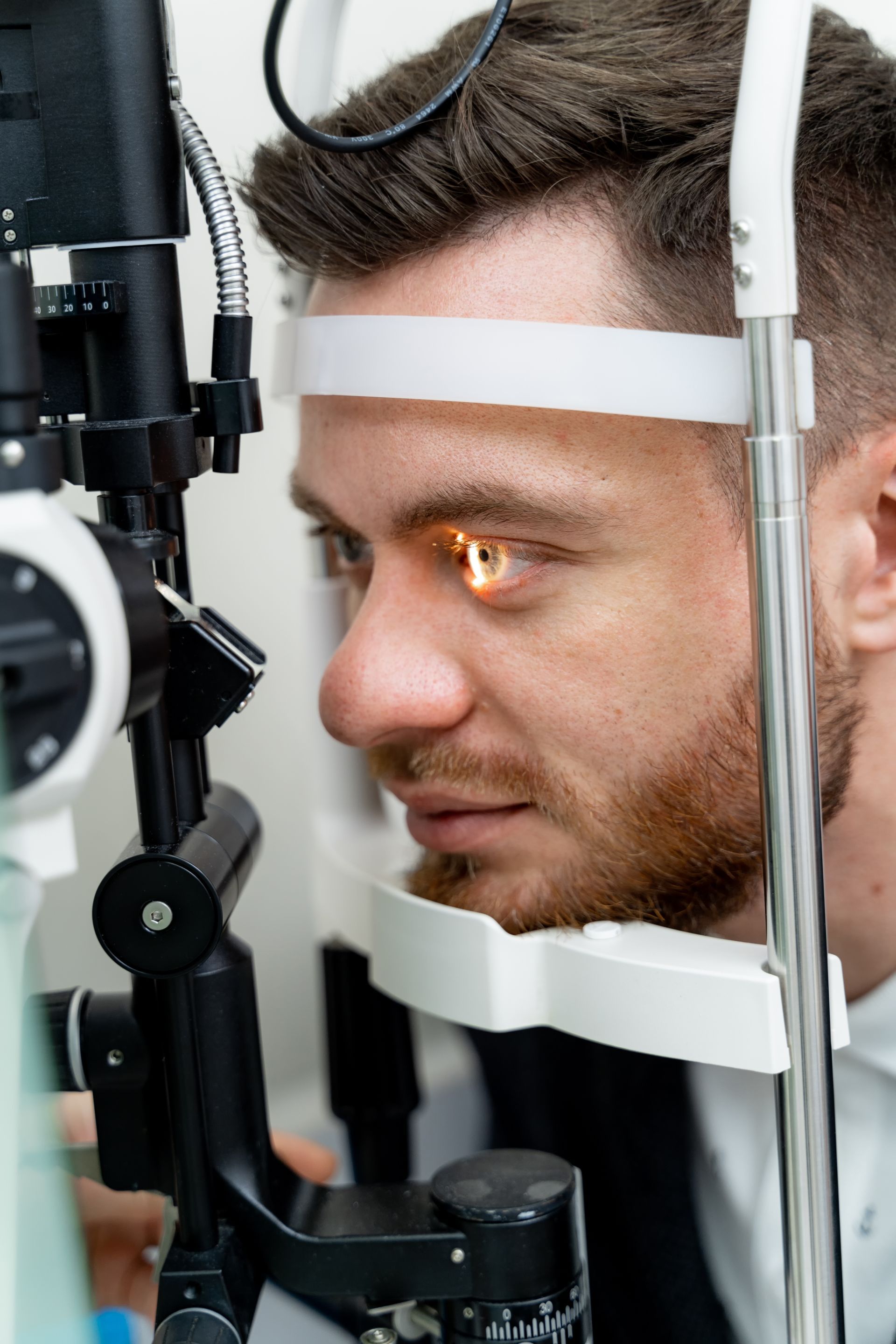 Patient undergoing an eye exam with a slit lamp in an optometrist’s office