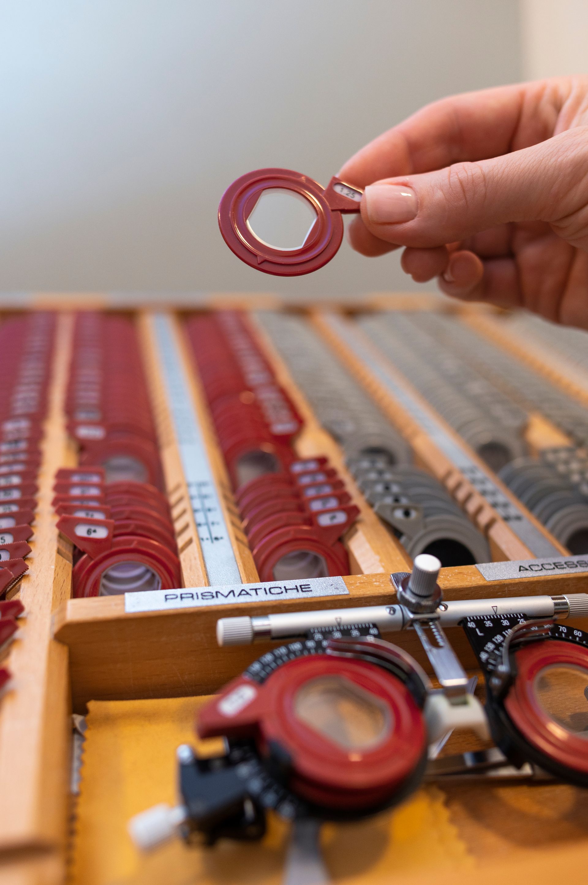 Hand holding a red gasket over an open case of assorted red and gray gaskets and tools