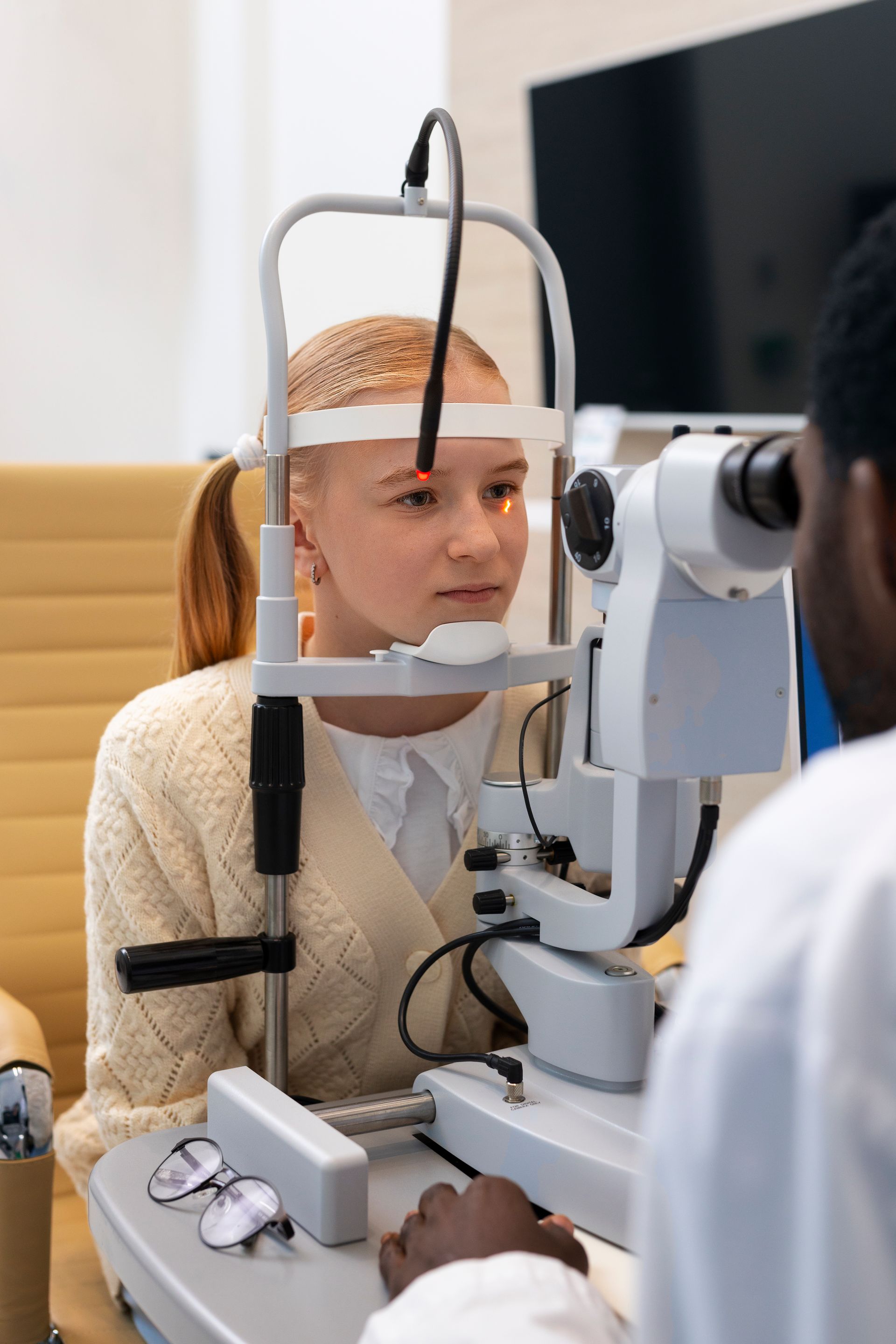 Patient undergoing eye exam with slit lamp at an optometrist's office