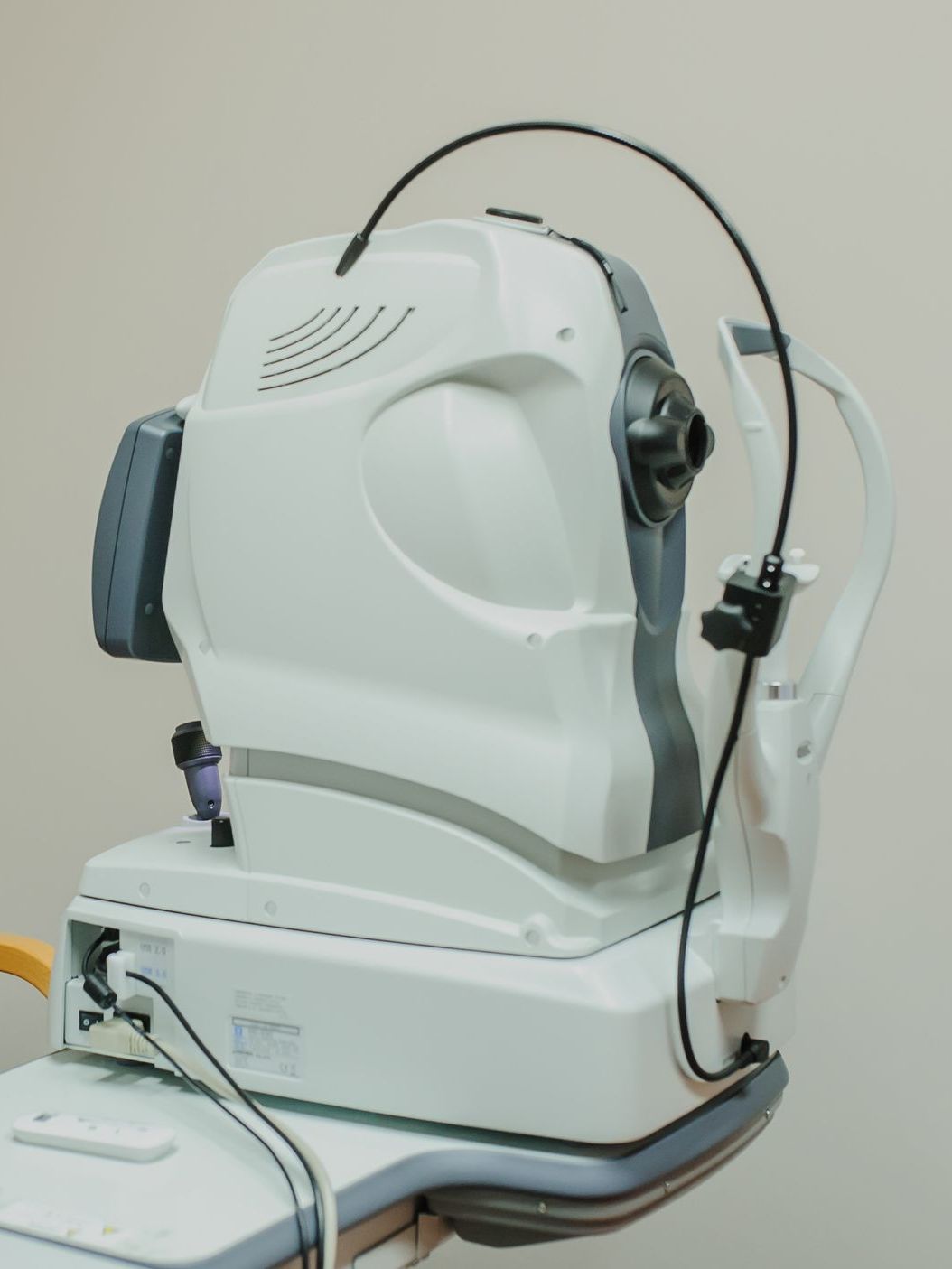 White ophthalmic testing machine with a black cable in a clinical setting