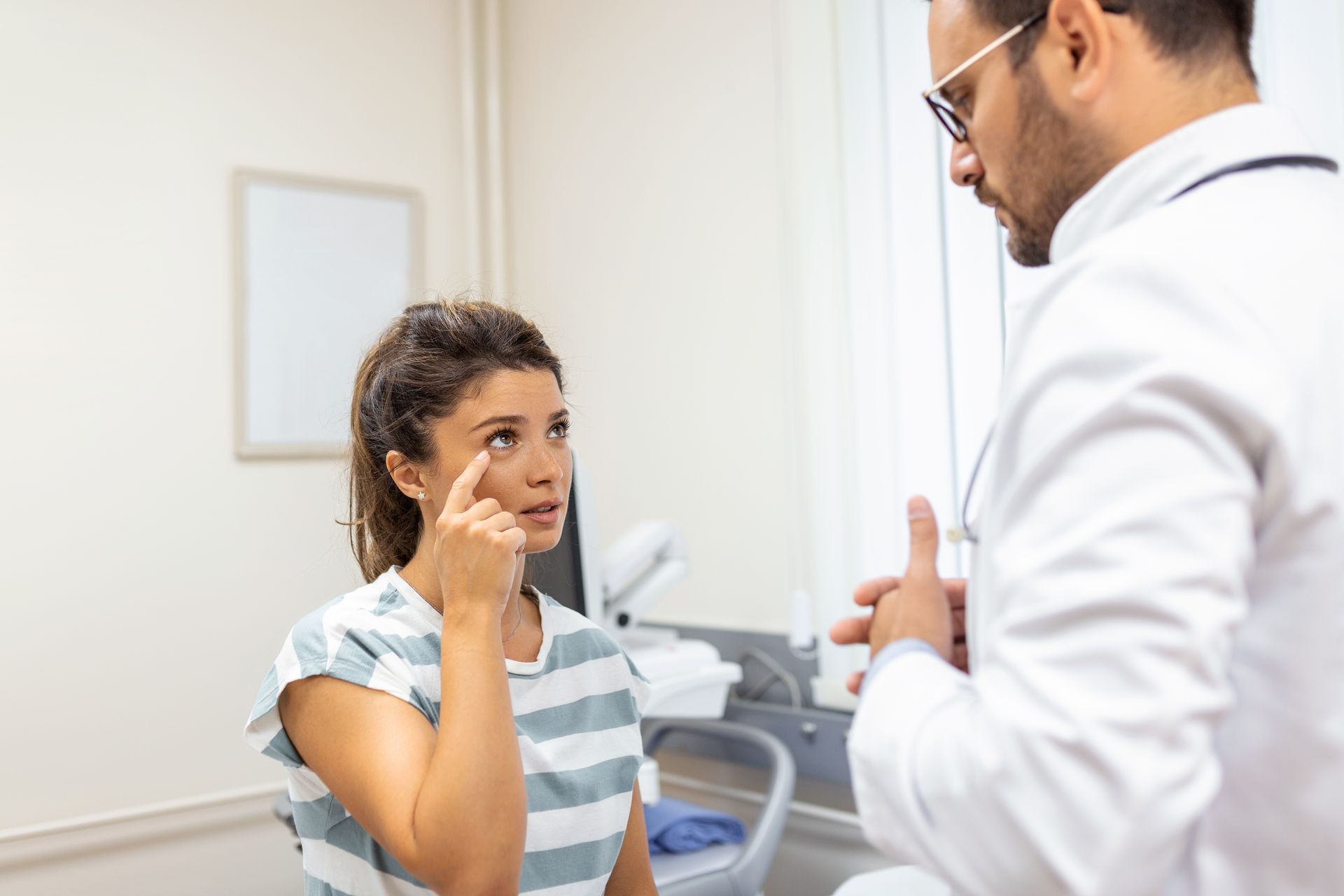 A doctor is examining a patient 's eye in a hospital.